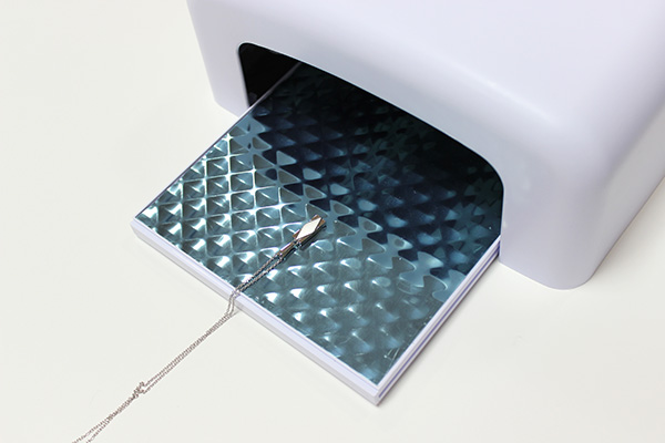 遺骨封入作業手順③の写真：特殊な接着剤と機械を使用し、専用の機械で照射して固定致します。